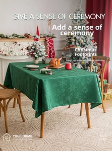 Detail of forest green Christmas tablecloth with snowflake patterns in a cozy dining setting