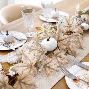 Autumn garland featuring white pumpkins and maple leaves on a rustic dining table decoration