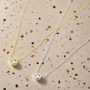 Dettaglio delle collane in argento 925 dorato con ciondoli a chicco con diamanti incastonati