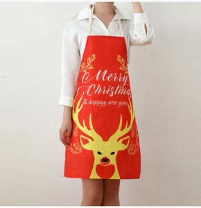 Detailed view of red Christmas apron with yellow reindeer print and festive text