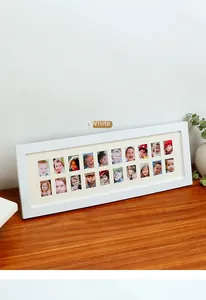 Detailed view of white 18-opening school photo frame on a wooden desk with green plants