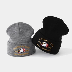 Close-up of 250th Anniversary eagle embroidery on grey and black knit beanies