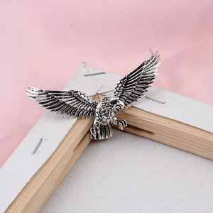 Close-up of soaring eagle brooch with vintage silver finish and green gemstone eye