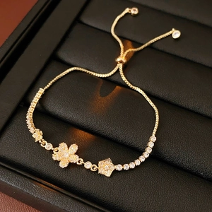 Macro di bracciale a fiori dorato con zirconi e catena regolabile su pelle nera elegante