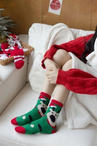 Close-up of cozy green coral fleece Christmas socks featuring a cute reindeer pattern