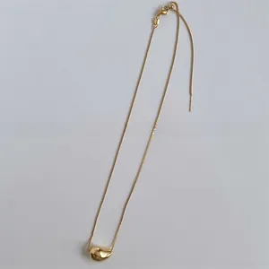 Detail of gold water drop pendant with adjustable slider chain and needle pin clasp