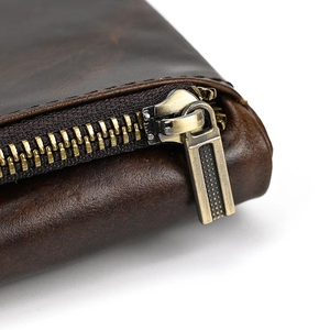 Macro shot of durable vintage copper zipper on premium dark brown leather wallet