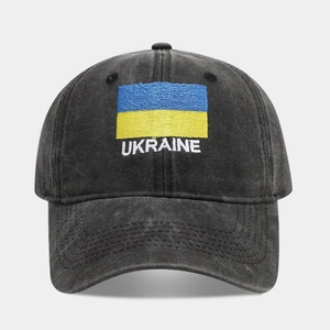 Close-up of Ukraine flag embroidery and white text on a washed dark grey cotton baseball cap
