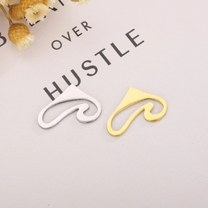 Detail of hollow heart-shaped wave pendants in gold and silver for DIY jewelry