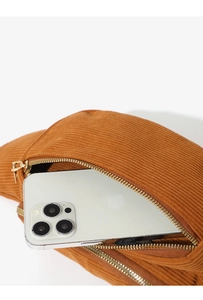 Detailed close-up of brown corduroy waist bag with textured fabric and gold metal zipper