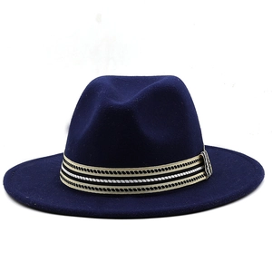 Dettaglio cappello fedora blu navy con nastro a righe nero bianco e oro stile elegante
