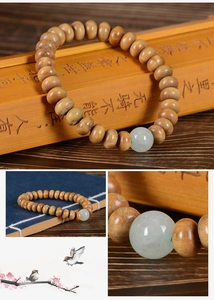 Gros plan de perles en bois de santal avec perle de jade sur des lamelles de bambou