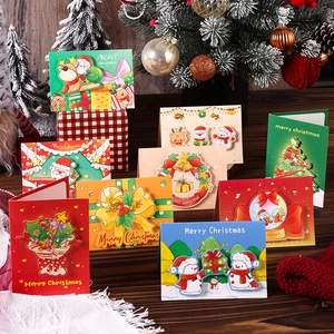 3D pop-up Christmas cards featuring Santa and snowmen displayed on a wooden table