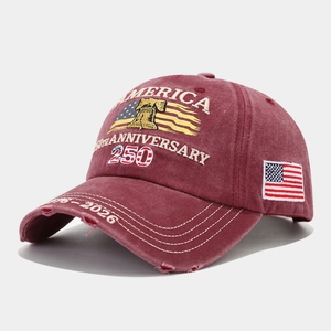 Detail of burgundy washed cotton baseball cap with vintage embroidery and worn-out brim