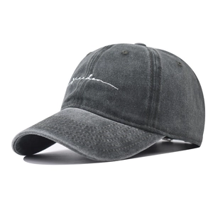 Detail showing white freedom embroidery on washed dark grey cotton baseball cap