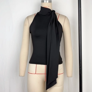 Detail eines schwarzen Halterneck-Tops mit eleganter Schleife und seidiger Stoffstruktur