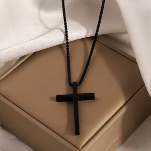 Minimalist black matte stainless steel cross necklace displayed on a luxury jewelry gift box