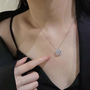 Silver four-leaf clover pendant necklace with pave heart-shaped crystals on model