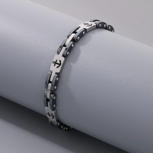 Detailed view of silver and black stainless steel anchor bracelet on a cylinder display