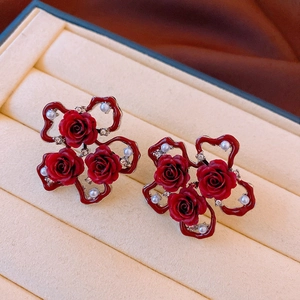Macro view of red rose earrings with pearls and crystals in a jewelry box