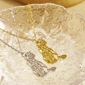 Detail of geometric cutout cat pendant necklaces in gold and silver stainless steel finishes