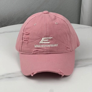 Detailed view of pink distressed cotton baseball cap with white letter E embroidery
