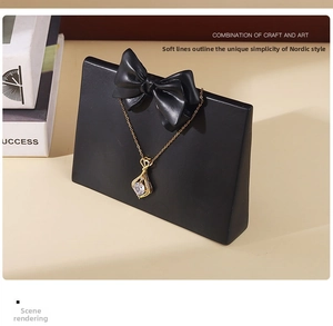 Detail of gold teardrop pendant necklace with clear crystal on black jewelry display stand
