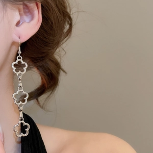 Detail of silver plum blossom hollow tassel earrings worn to show elegant drape effect