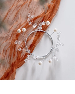 Detailed macro view of handmade silver floral hairpiece with pearls and crystal beads
