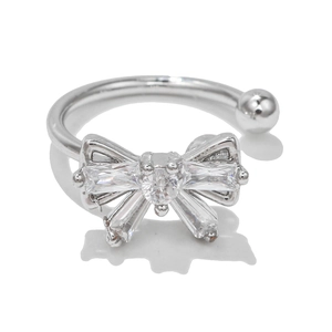 Close-up of silver bow ear cuff featuring sparkling pavé crystals and centered round gem