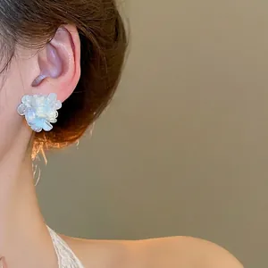 Elegant 3D pearlescent white flower stud earrings worn by model for daily fashion look