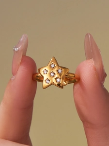 Close-up of star-shaped 18k gold plated ring with micro-pave crystals on a model hand