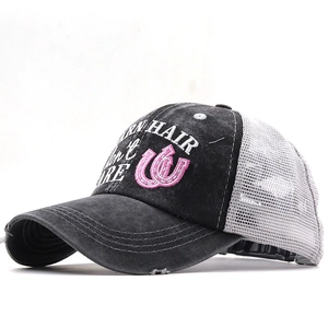 Detail of cross ponytail hole on black washed trucker hat with pink horseshoe embroidery
