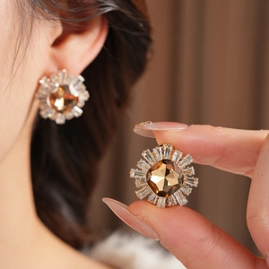 Détail macro de boucles d'oreilles tournesol avec pierre champagne et zircon blanc