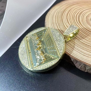 Close-up of gold iced-out circular Last Supper pendant with shimmering rhinestones