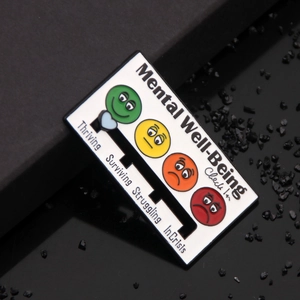 Detail of Mental Well-Being Check In enamel pin with sliding heart on black stone background