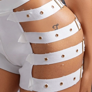 Detail von weißen High-Waist-Shorts mit seitlichen Ausschnitten und goldenen Schnallen