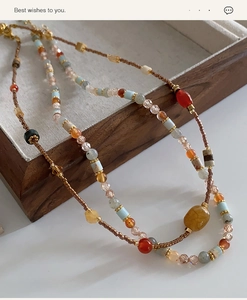 Macro view of handmade beaded necklace with natural agate stones and golden metal accents