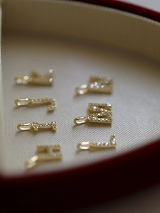 Close-up of gold-plated S925 silver letter pendants with sparkling pavé cubic zirconia