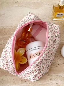 Pink floral cotton makeup bag with large capacity and zipper shown on a stone surface