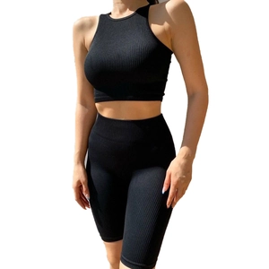 Dettaglio del set sportivo nero con pantaloncini a vita alta e crop top senza maniche