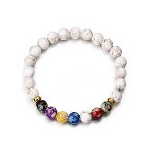 7 Chakra stone beaded bracelet with white lava rocks and golden crown accents on white background