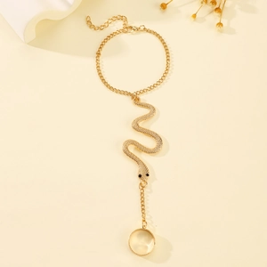 Elegant gold snake slave bracelet ring with chain for women on minimalist warm background