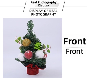 Close-up of a mini Christmas tree with festive gold, red, and white ornaments and a red base