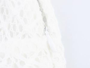 Detail of the high-quality invisible zipper on a white lace off-shoulder dress