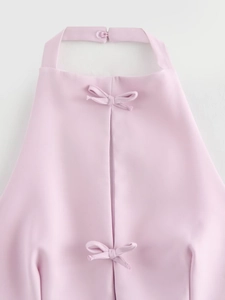 Detail of pink halter top with double bow decoration and back slit design