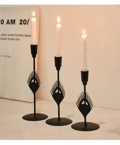 Detailed view of black metal candle holders with peacock feather design and spiral candles