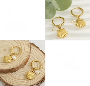 Détail de boucles d'oreilles coquillage plaquées or 18K avec perles sur fond en bois