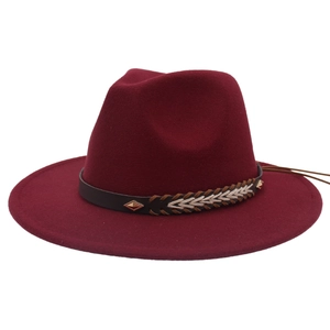 Detail of dark red wool fedora featuring a brown band and gold diamond metal ornament
