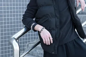 Détail d'un bracelet gourmette bicolore noir et argent pour homme avec bague simple